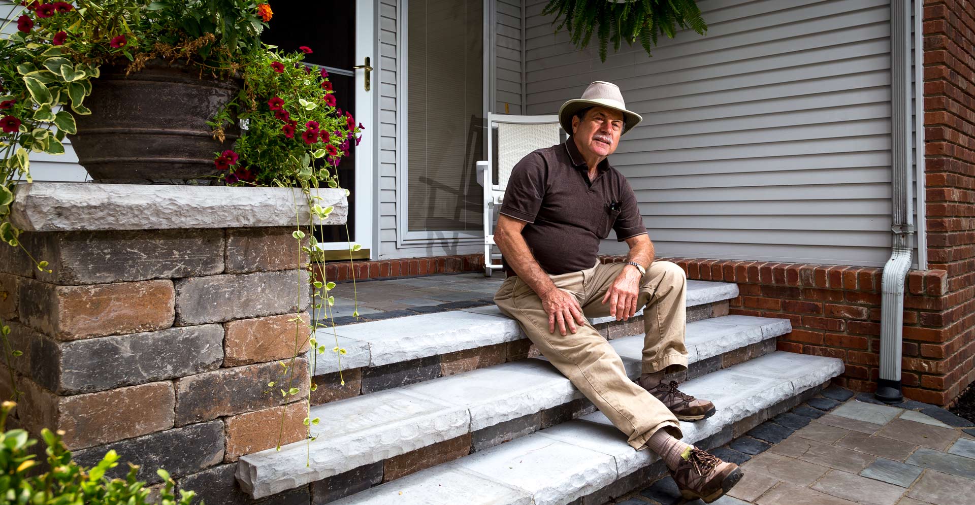 John Bundschuh, owner and president of Bundschuh Landscape Center sitting on Unilock Ledgestone steps and porch